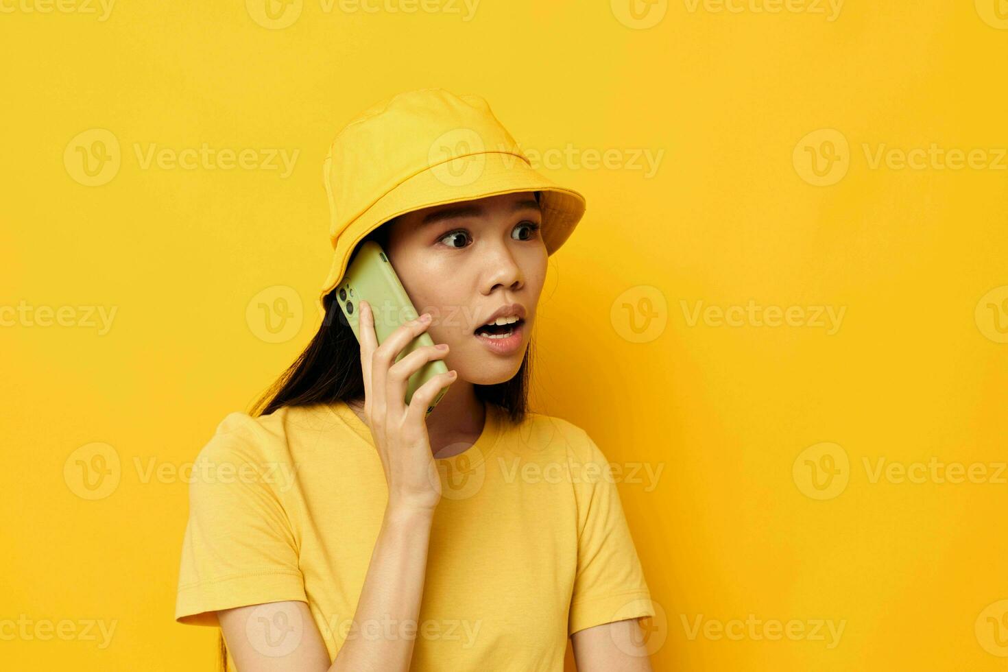 retrato asiático hermosa joven mujer en un amarillo sombrero y camiseta hablando en el teléfono estilo de vida inalterado foto