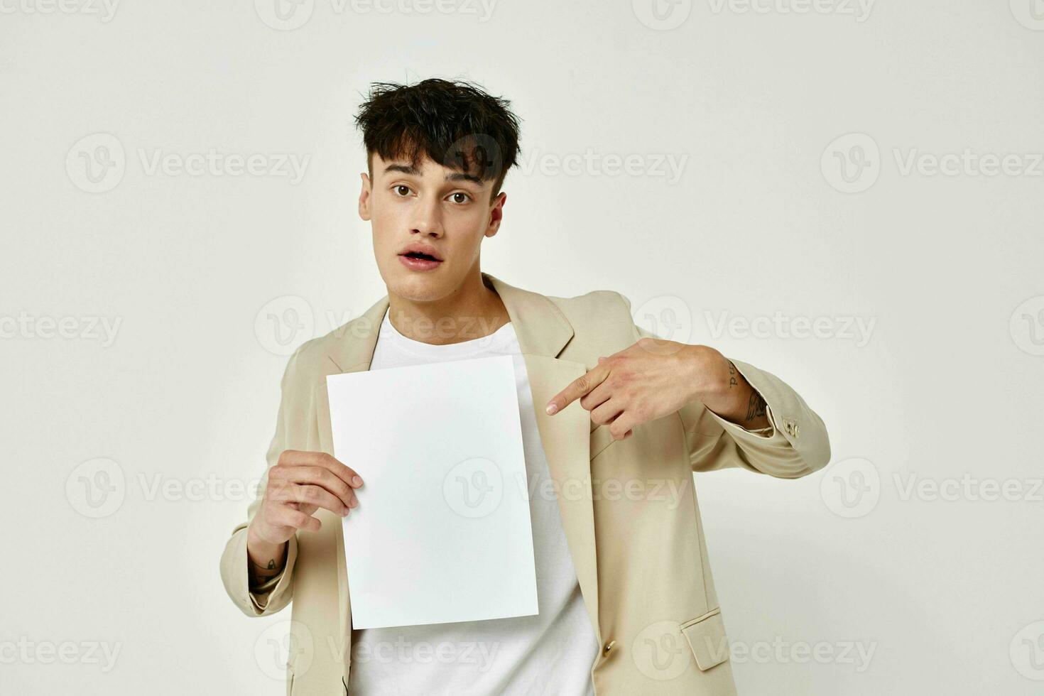 portrait of a young man in a beige suit copy-space notebook light background unaltered photo