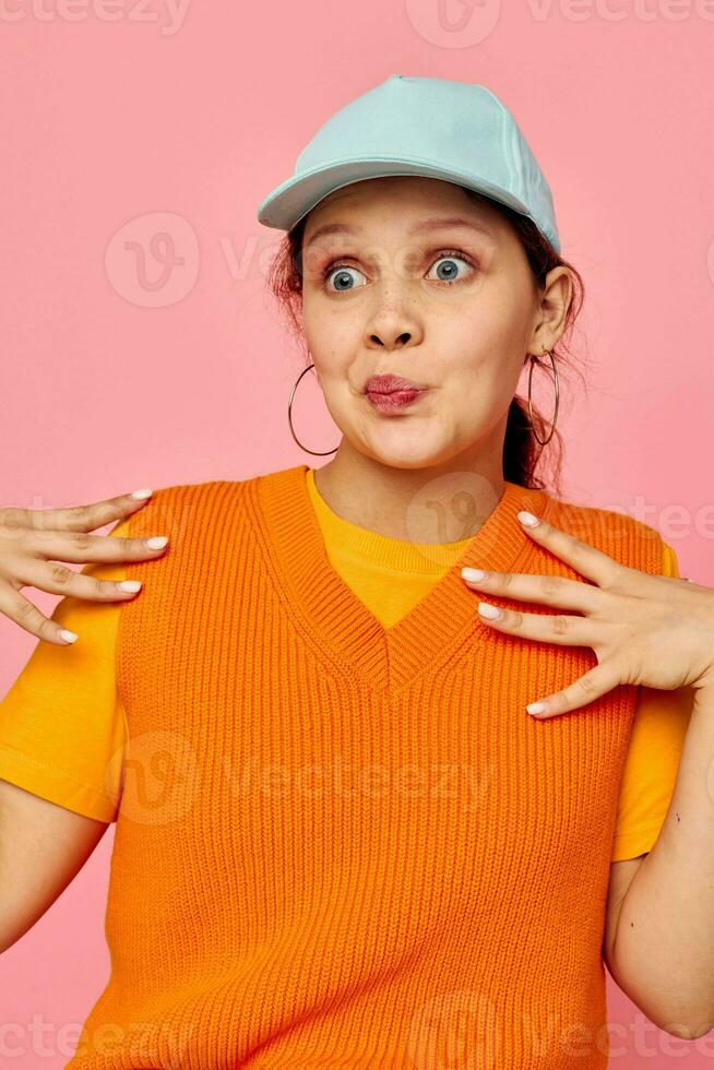 beautiful woman in an orange sweater in blue caps hand gesture cropped view unaltered photo