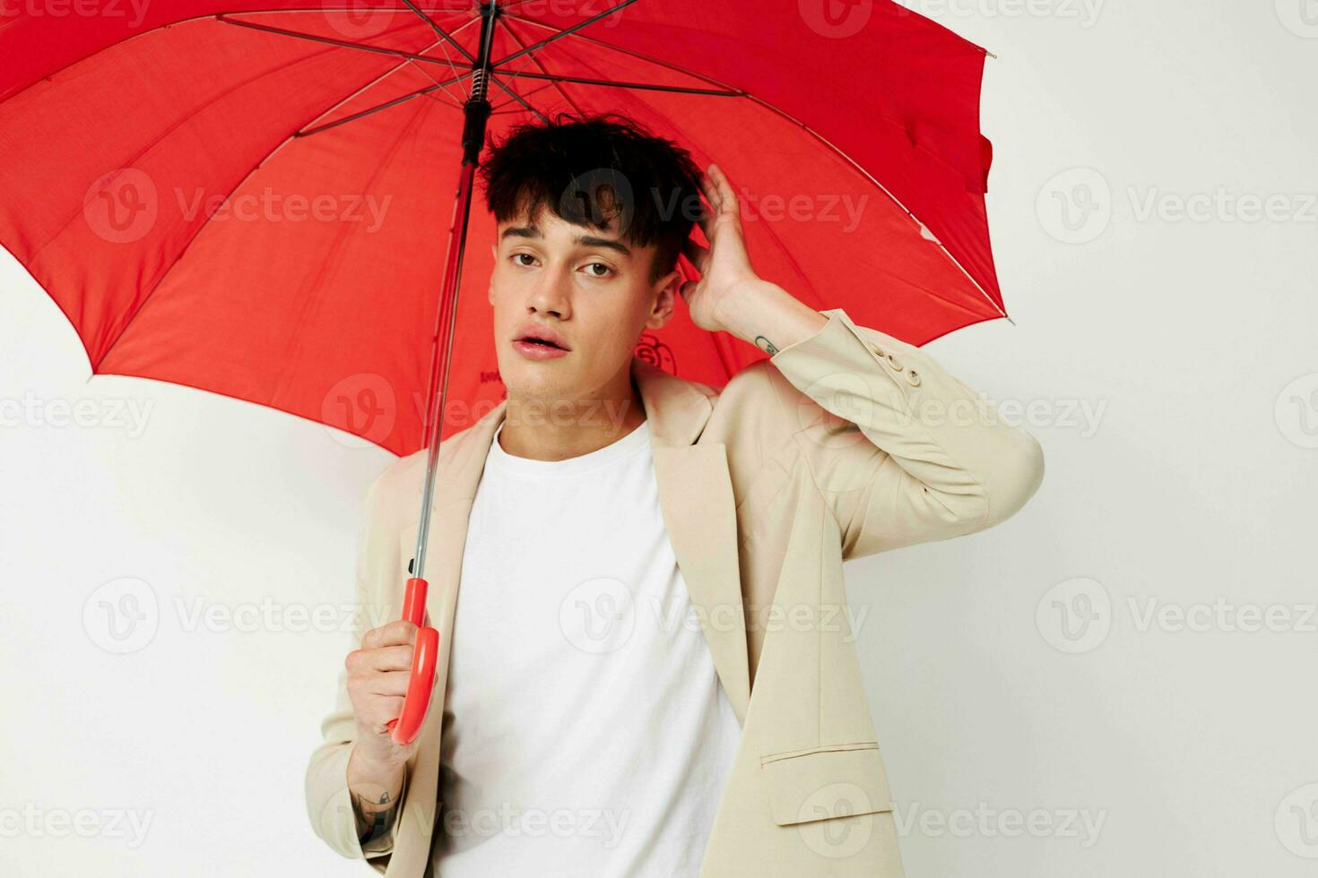Man holding an umbrella in the hands of posing fashion light background unaltered photo