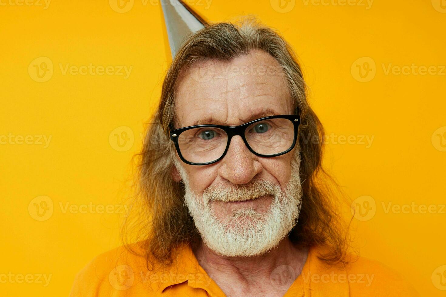 cheerful elderly man in glasses with a cap on his head yellow background photo