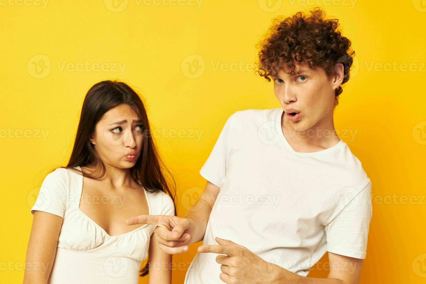 young boy and girl posing together in white t-shirts friendship yellow background unaltered photo