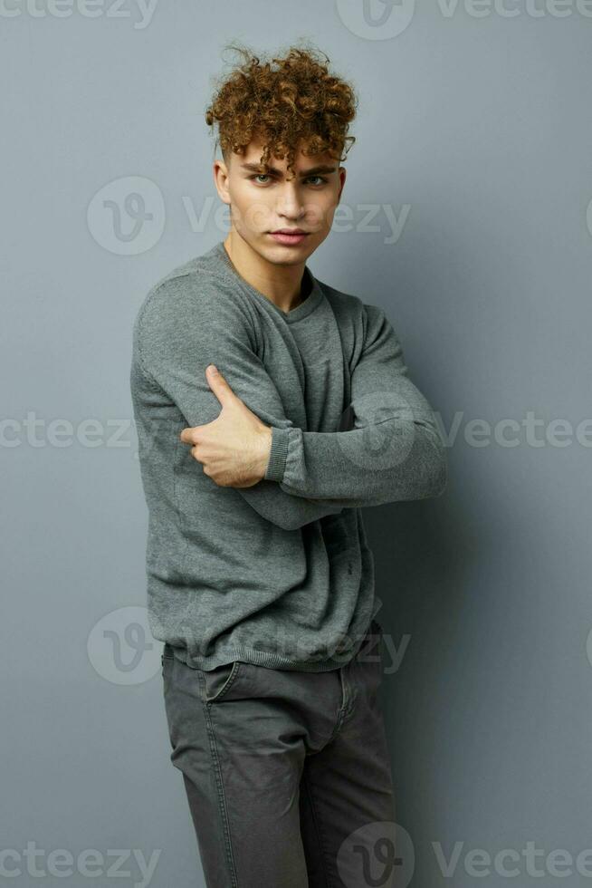 handsome young man in a gray sweatshirt fashion studio isolated background photo