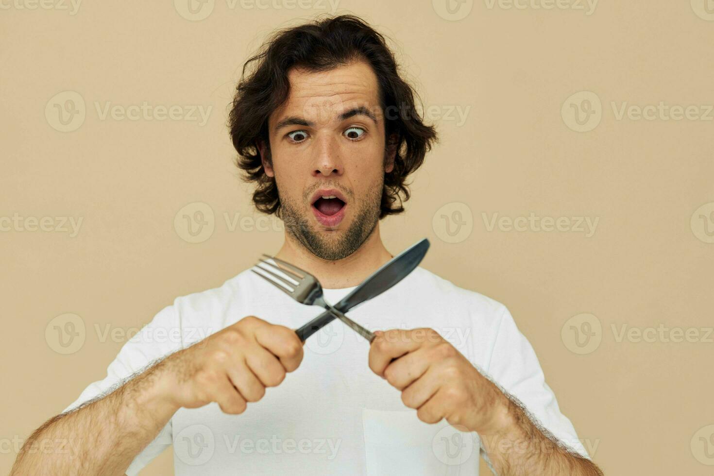 atractivo hombre emociones cuchillo y tenedor batería de cocina aislado antecedentes foto