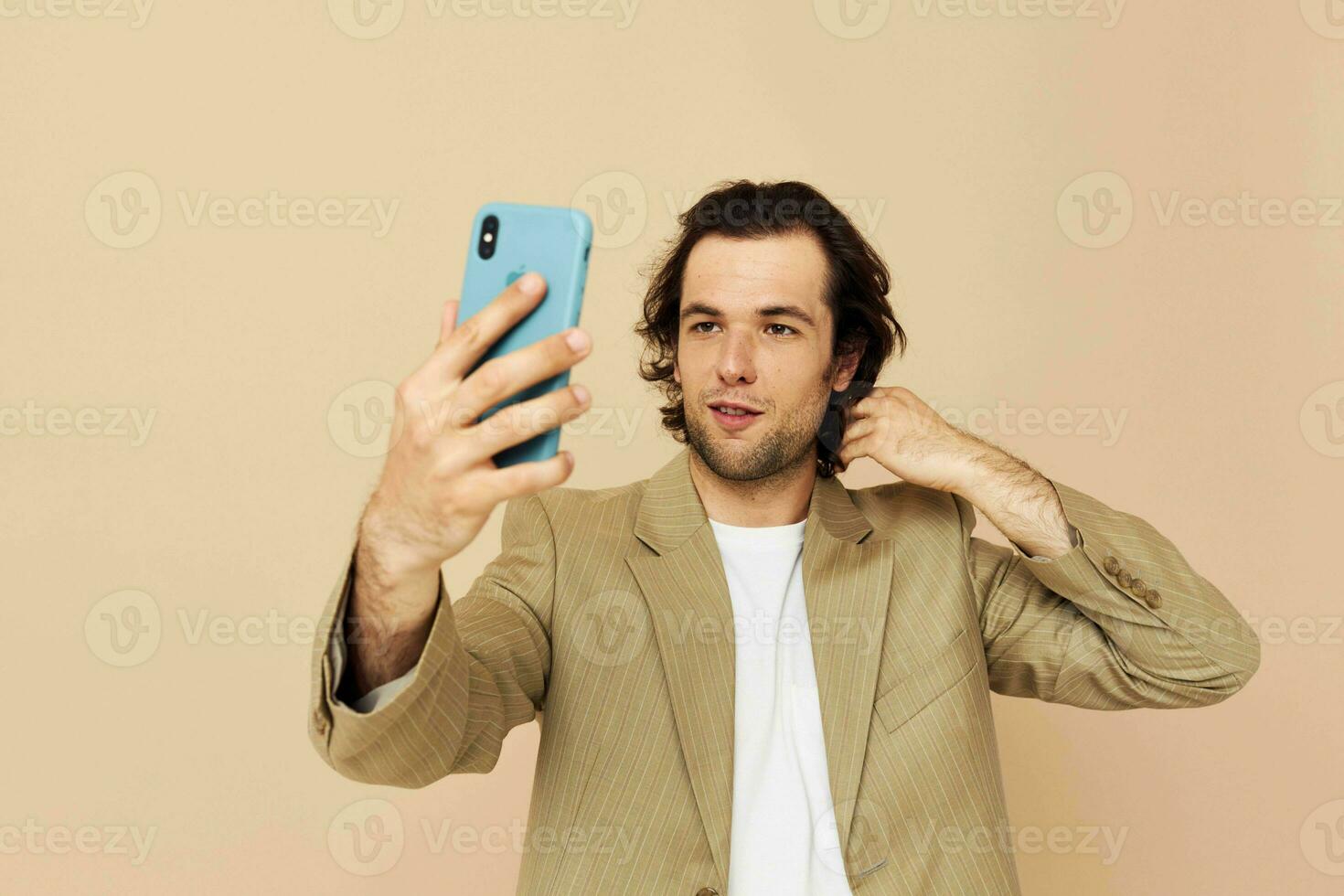 Cheerful man in a suit posing emotions looking at the phone isolated background photo