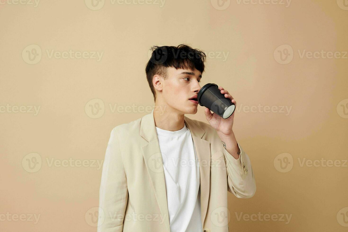 A young man a glass with a drink in hand modern style isolated background unaltered photo