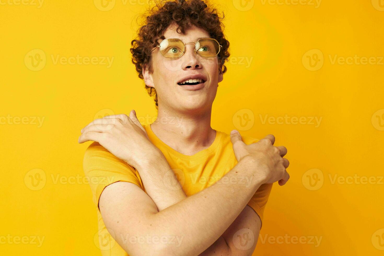 guy with red curly hair yellow t-shirt glasses fashion hand gestures yellow background unaltered photo