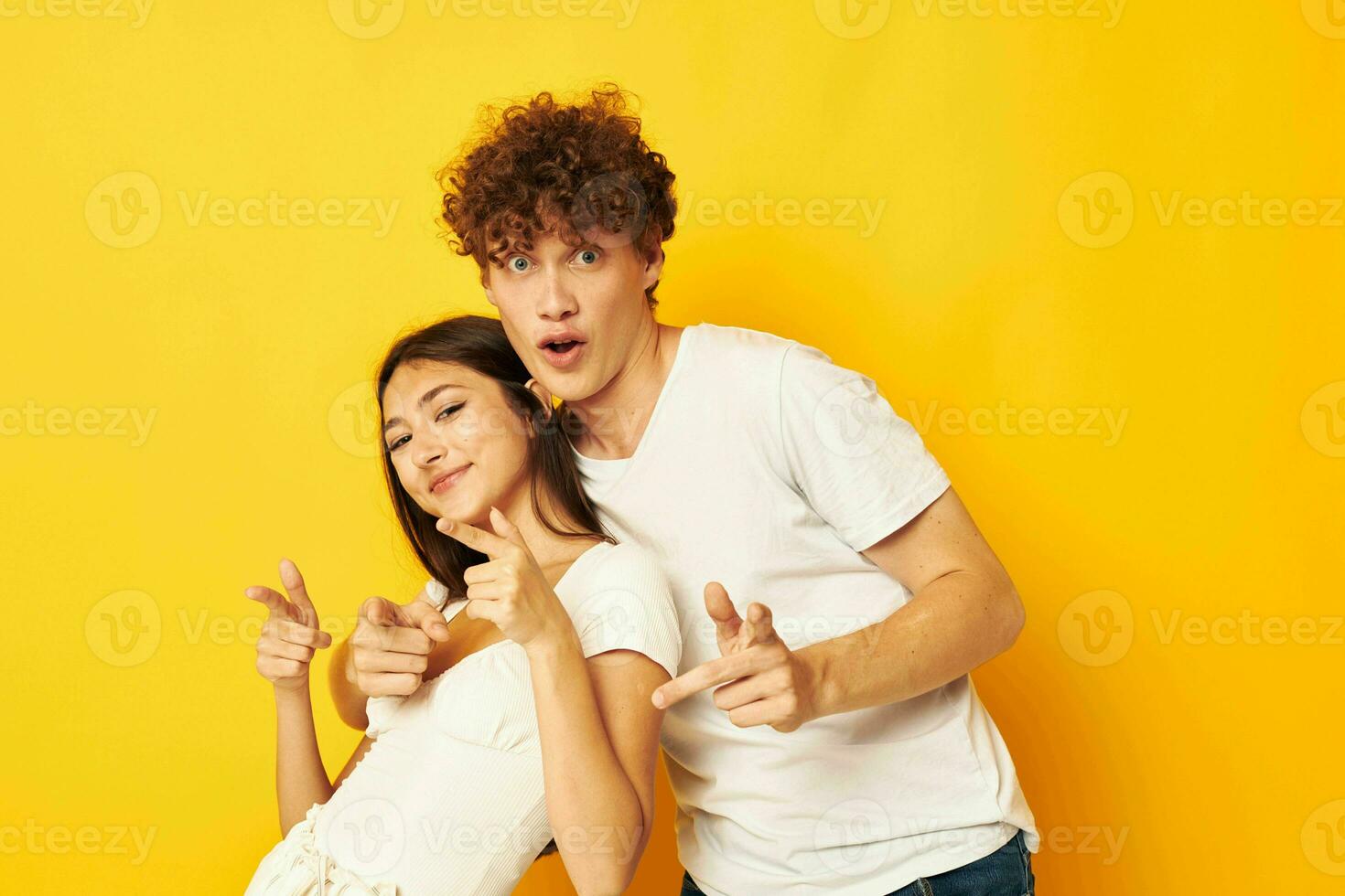 joven chico y niña en pie lado por lado en blanco camisetas posando amarillo antecedentes inalterado foto
