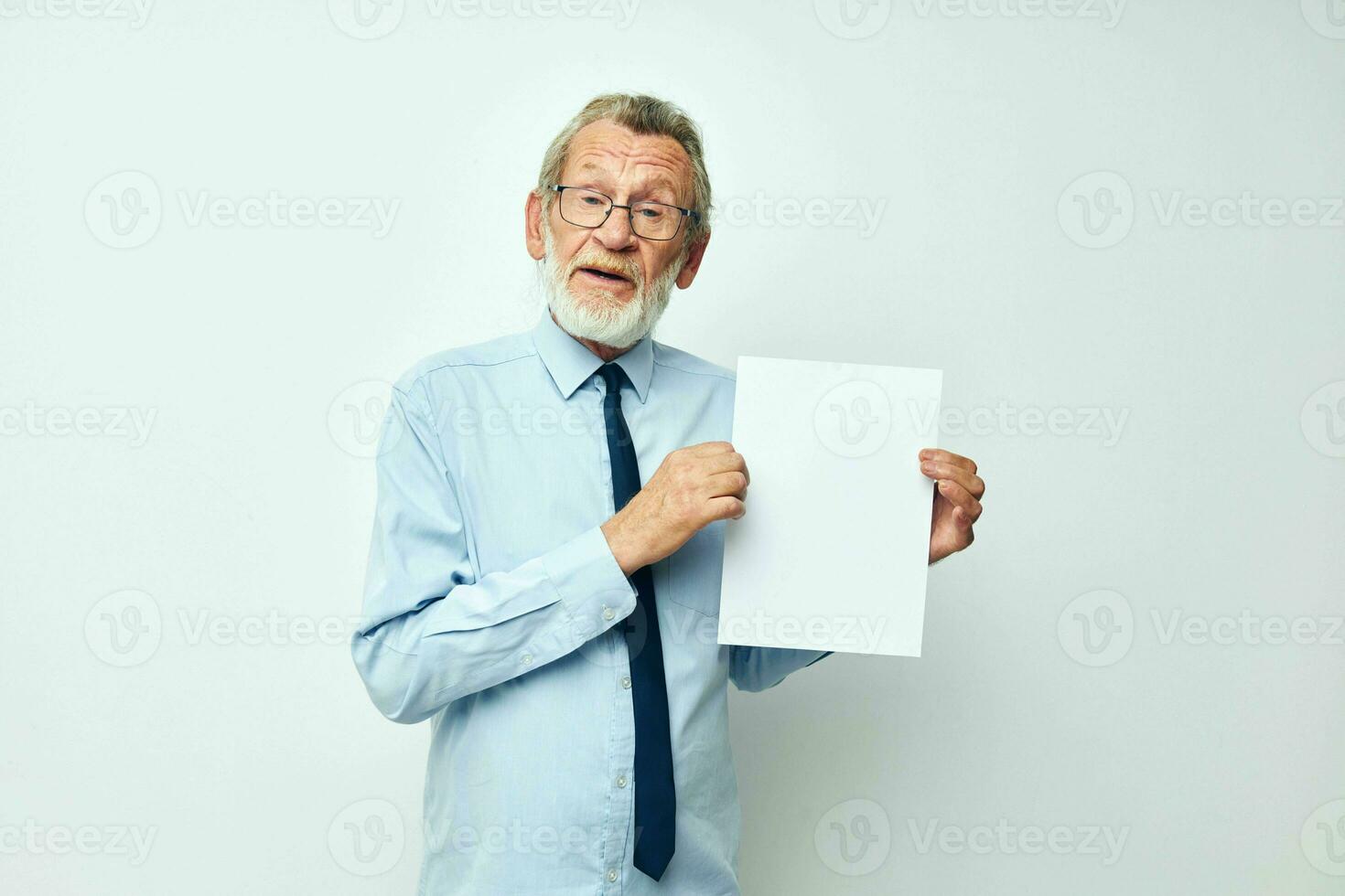 old man holding documents with a sheet of paper light background photo
