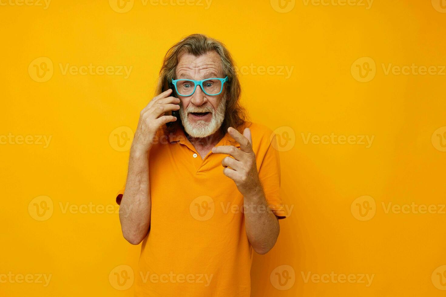 old man wearing blue glasses yellow shirt talking on the phone cropped view photo