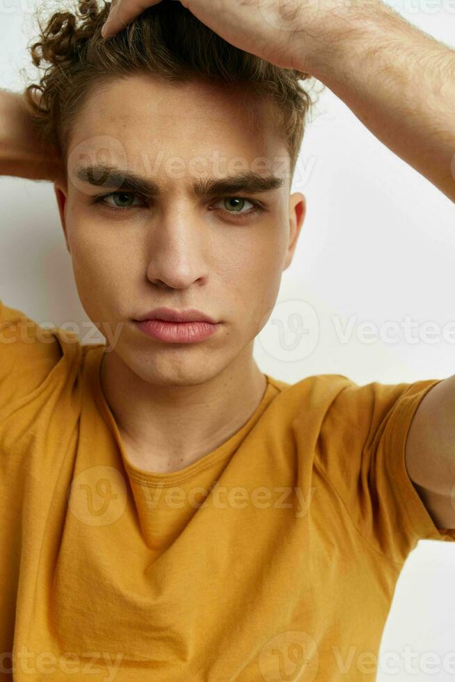 hermoso joven hombre en amarillo camisetas gesto manos emociones aislado antecedentes foto