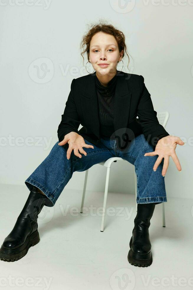 pretty woman black jacket jeans posing light background unaltered photo