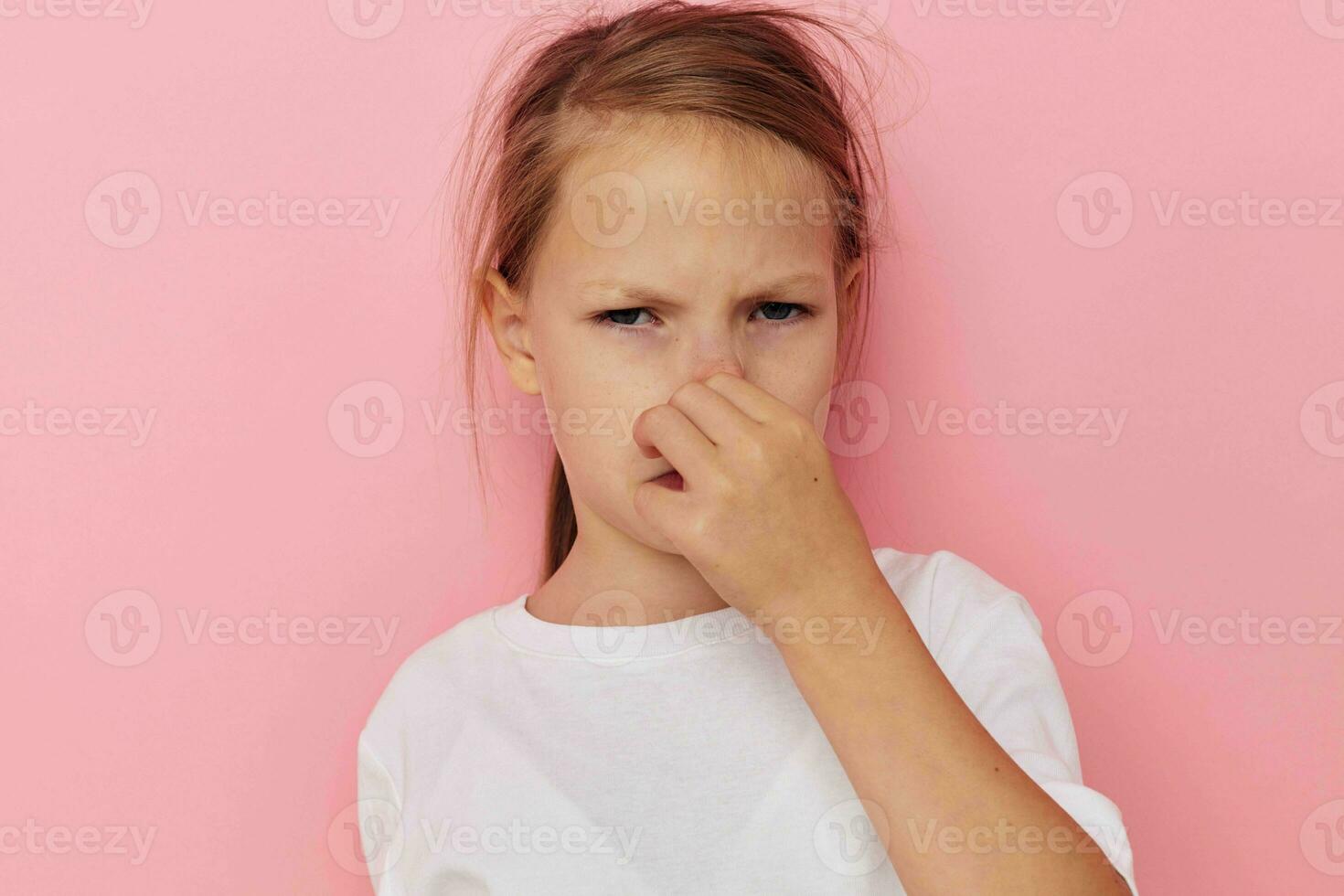 Portrait of happy smiling child girl in a white t-shirt smile pink background photo