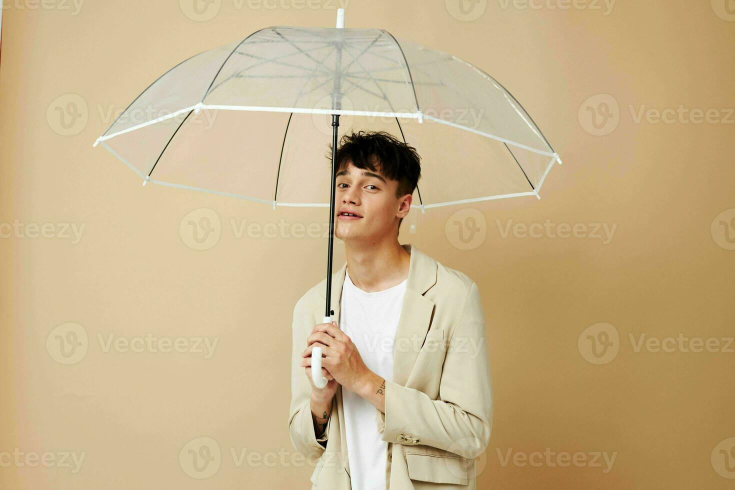 photo of a young guy in a white jacket with an open umbrella