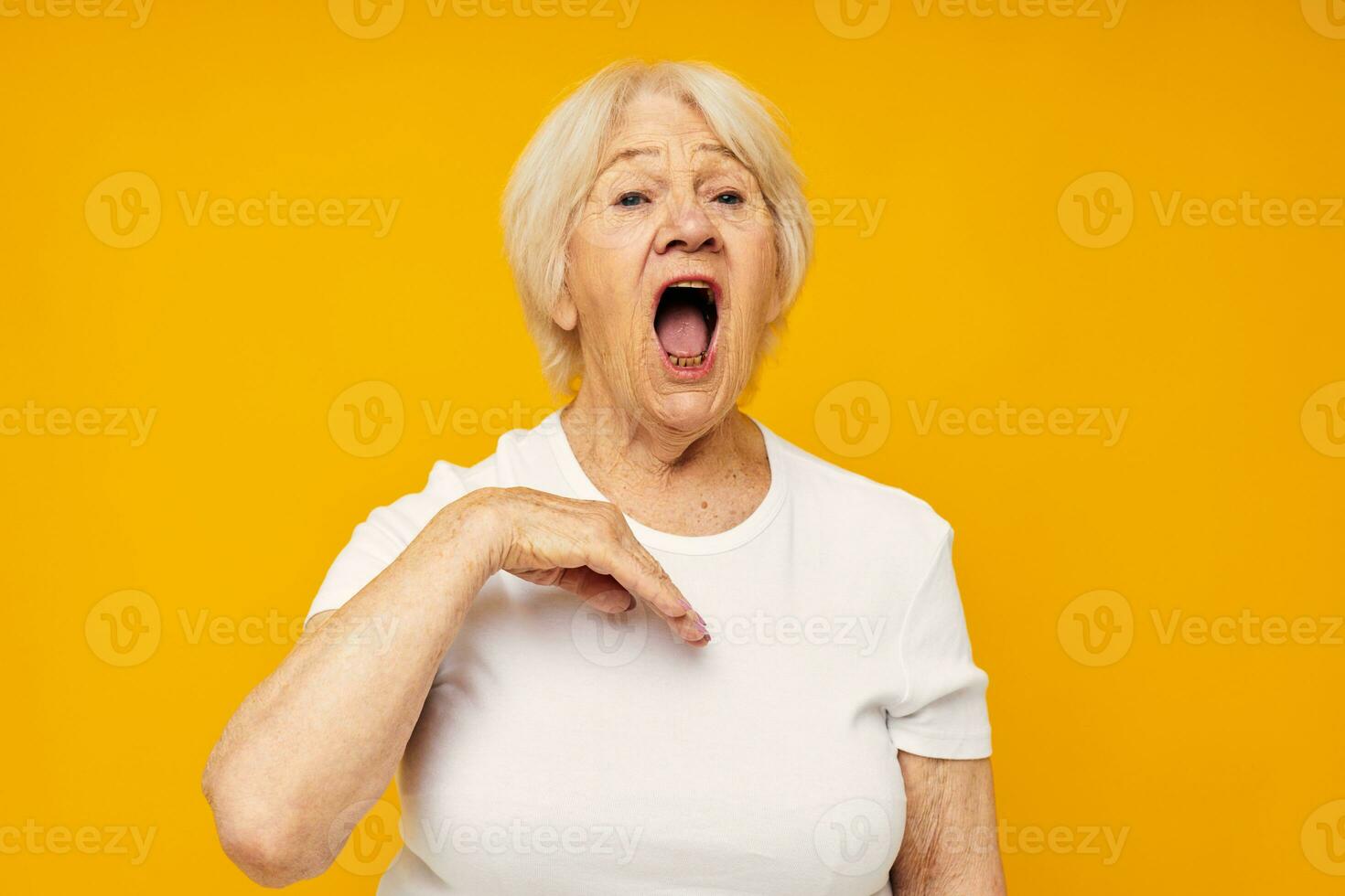Portrait of an old friendly woman in white t-shirt posing fun close-up emotions photo