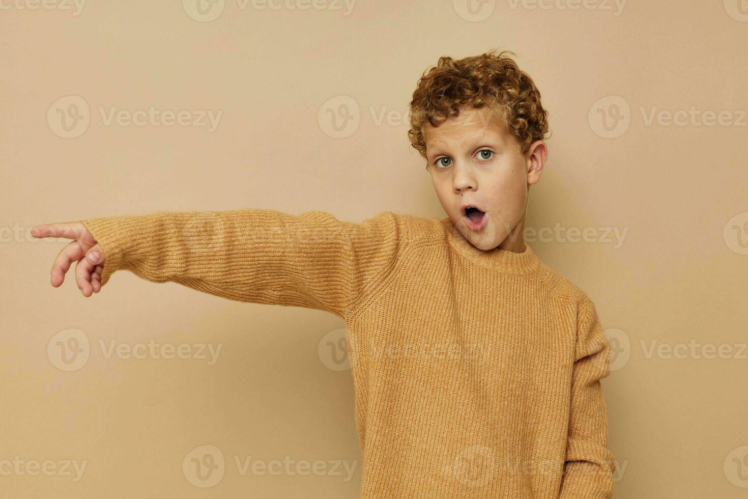 curly boy in a beige sweater posing fun childhood unaltered photo