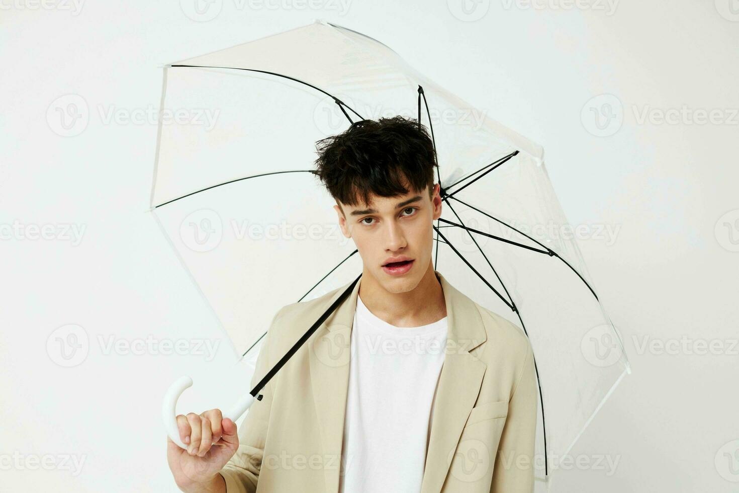 handsome guy transparent umbrella a man in a light jacket isolated background unaltered photo