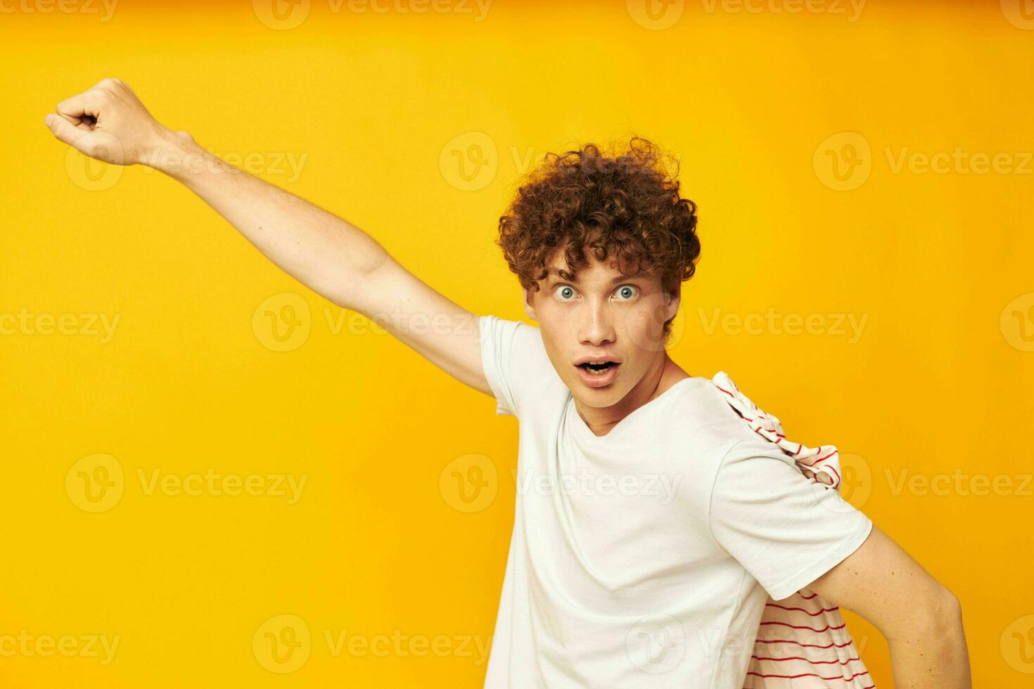 cute red-haired guy in a white t-shirt holds a striped t-shirt fashion youth style isolated background unaltered photo