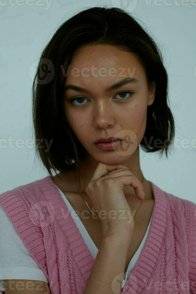 pretty brunette in pink vest posing hand gesture photo