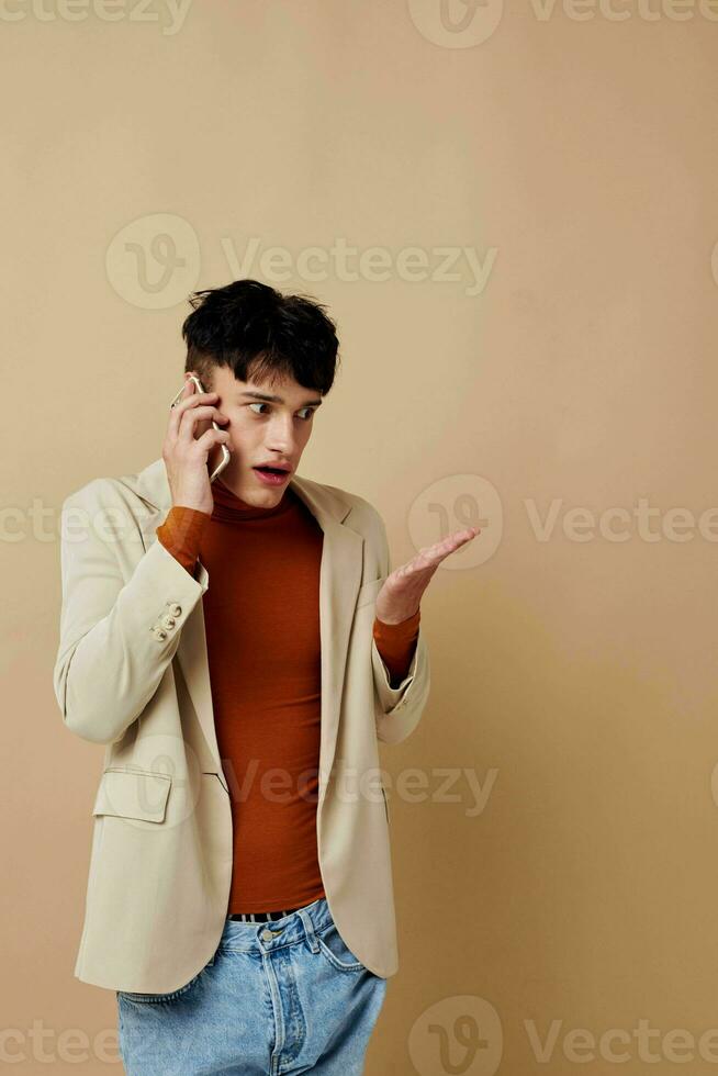 portrait of a young man mobile phone in the hands of communication in a suit fashion light background unaltered photo