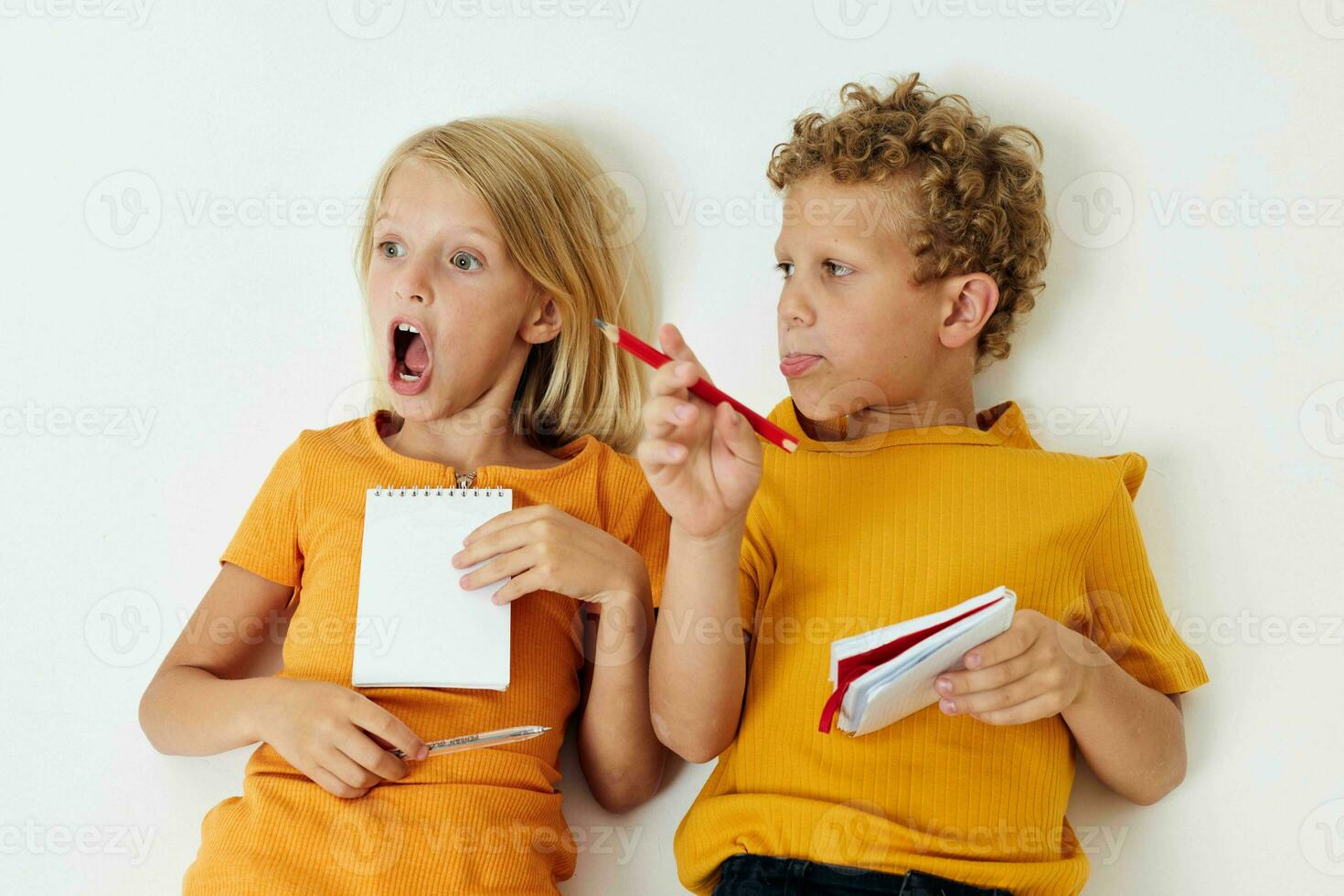 chico y niña mentira en el piso con libretas y lapices infancia estilo de vida inalterado foto