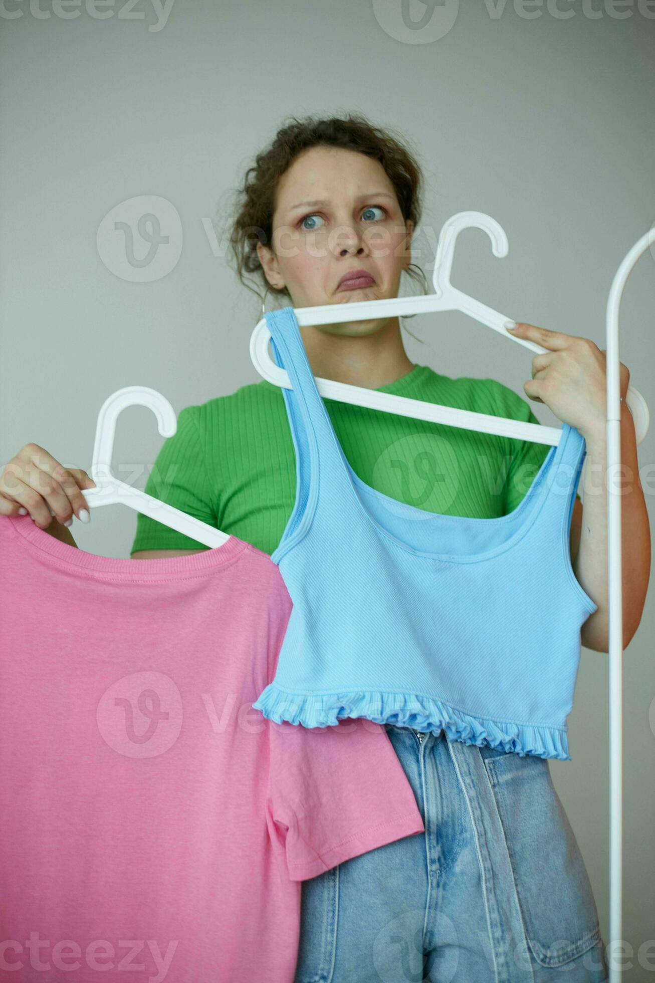 cheerful woman trying on clothes wardrobe Youth style light background