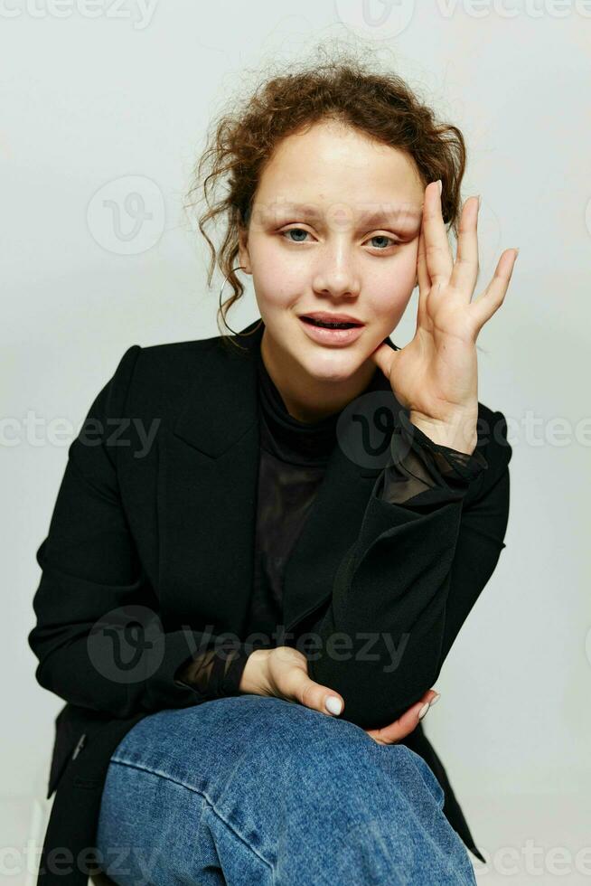 cheerful woman black jacket jeans posing light background unaltered photo