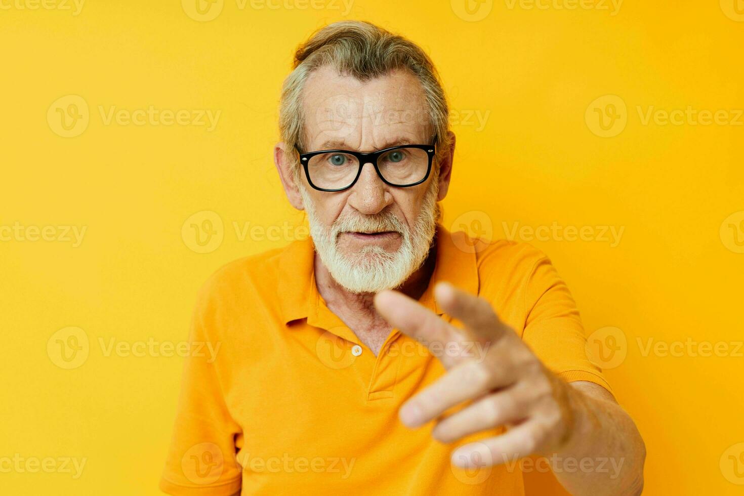 Portrait of happy senior man wearing glasses yellow shirt posing unaltered photo