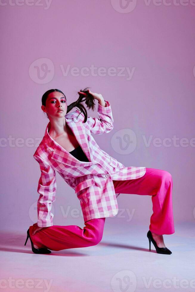 Portrait of beautiful young woman luxury clothing fashion plaid blazer pink background unaltered photo