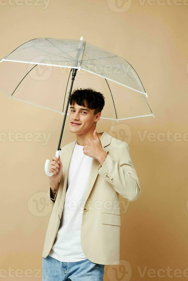 photo of a young guy in a white jacket with an open umbrella