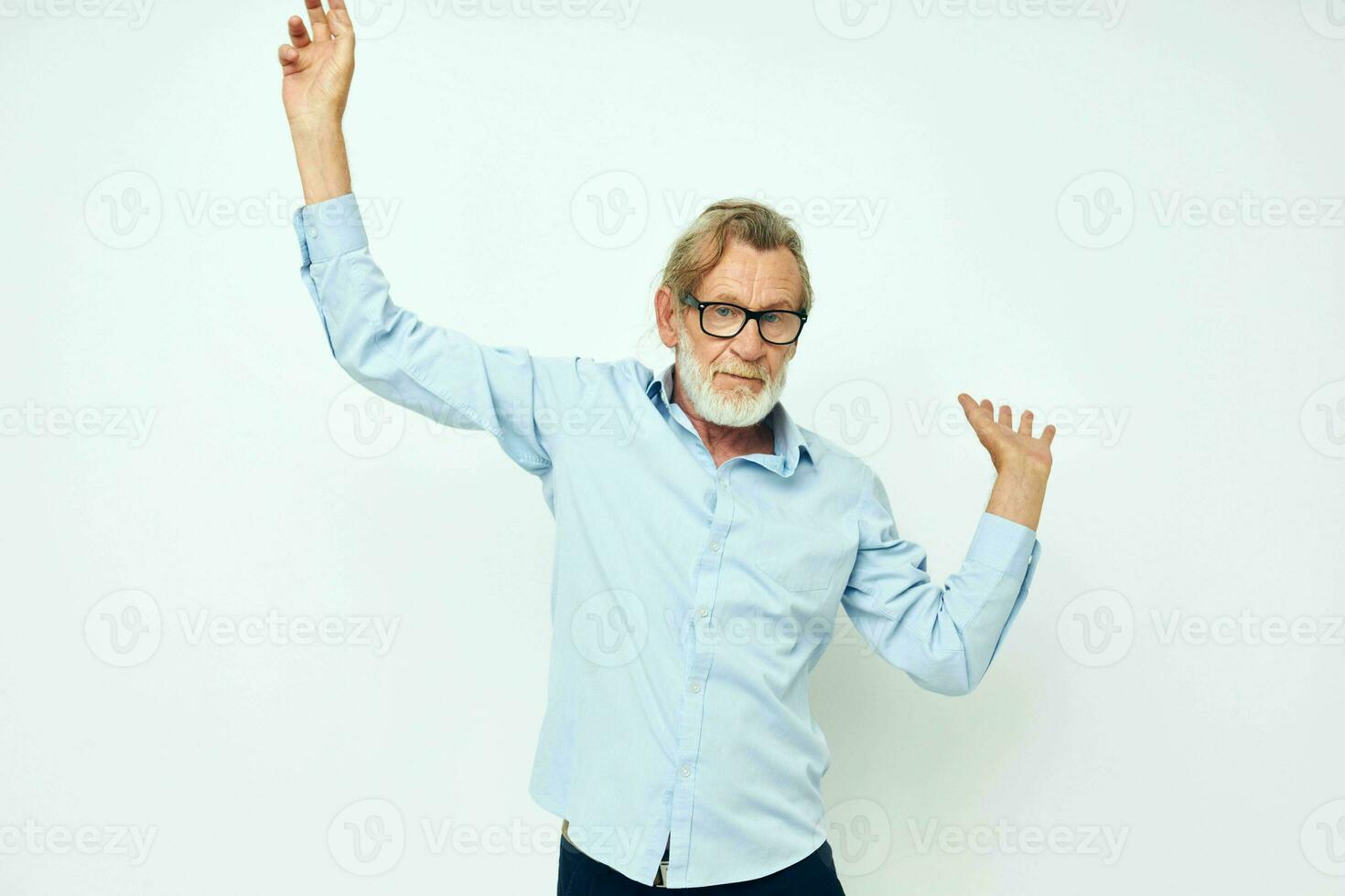 Senior grey-haired man in blue shirts gestures with his hands isolated background photo