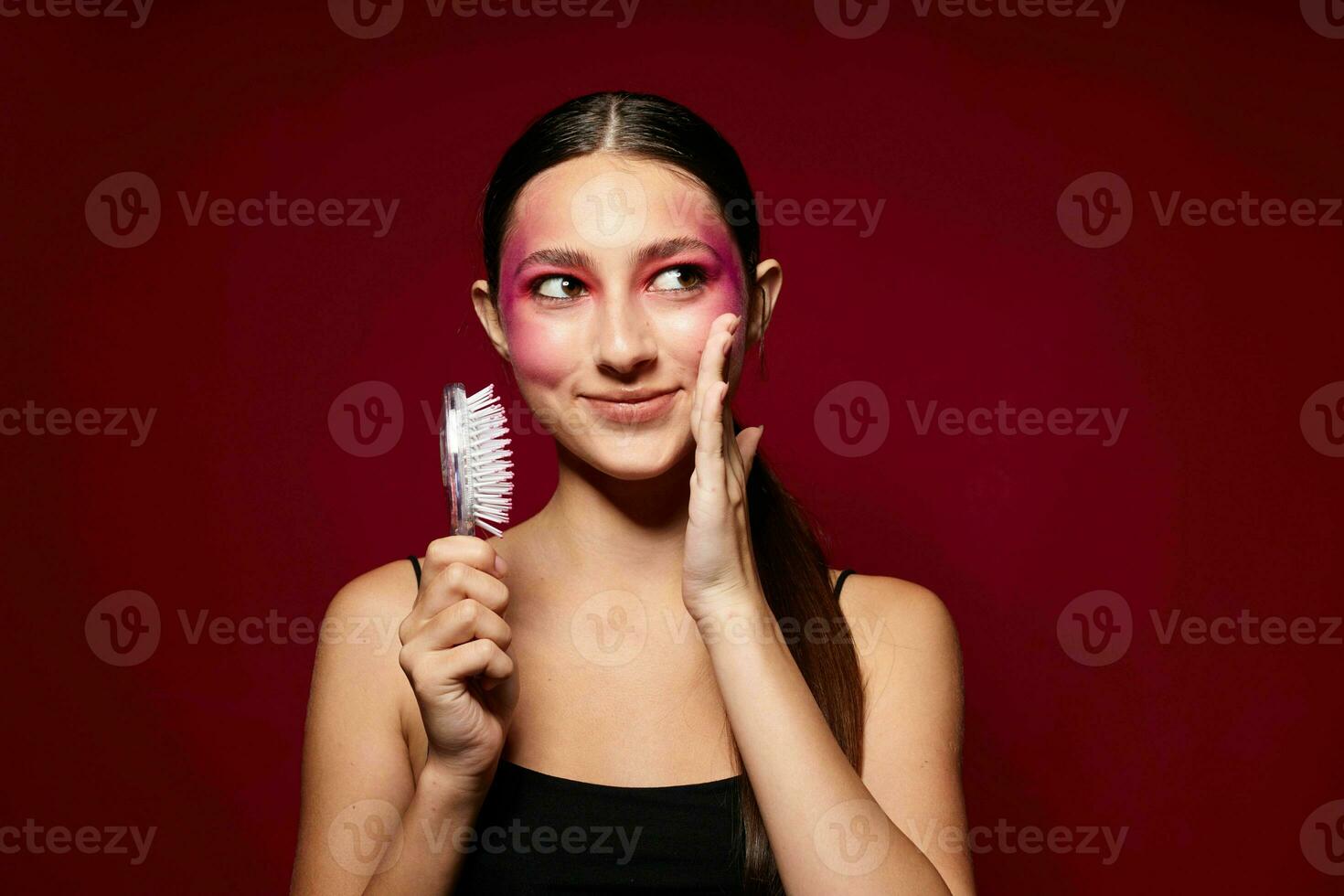 Portrait of beautiful young woman pink face makeup posing attractive look with a comb close-up unaltered photo