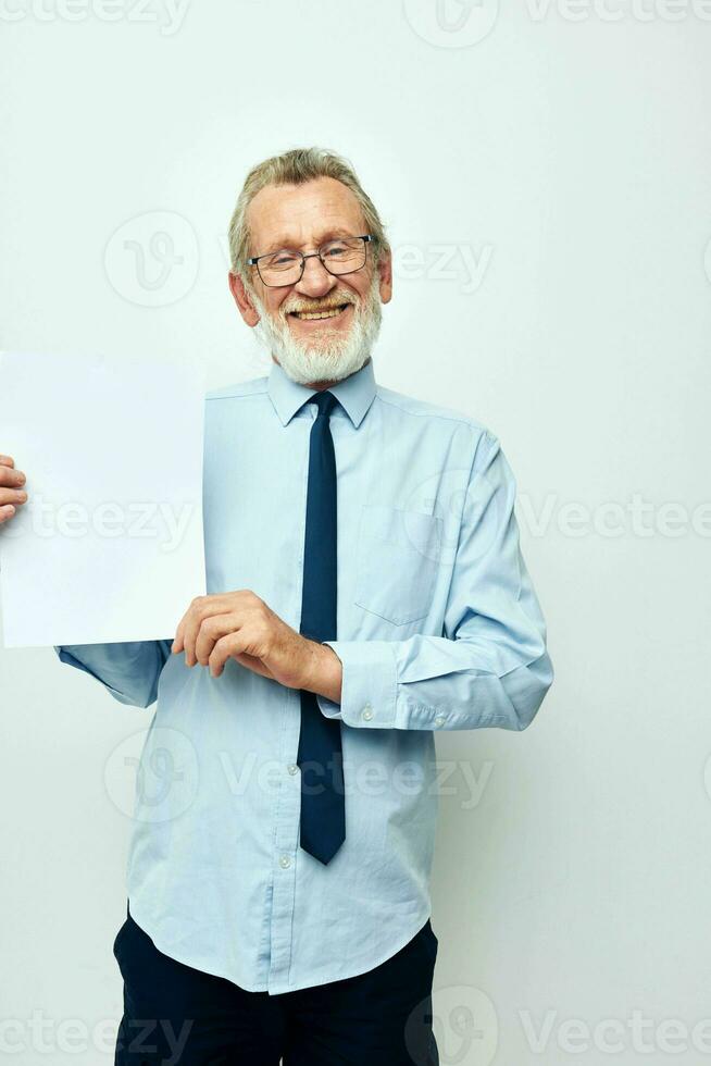 Portrait of happy senior man in a shirt with a tie copy-space sheet of paper cropped view photo