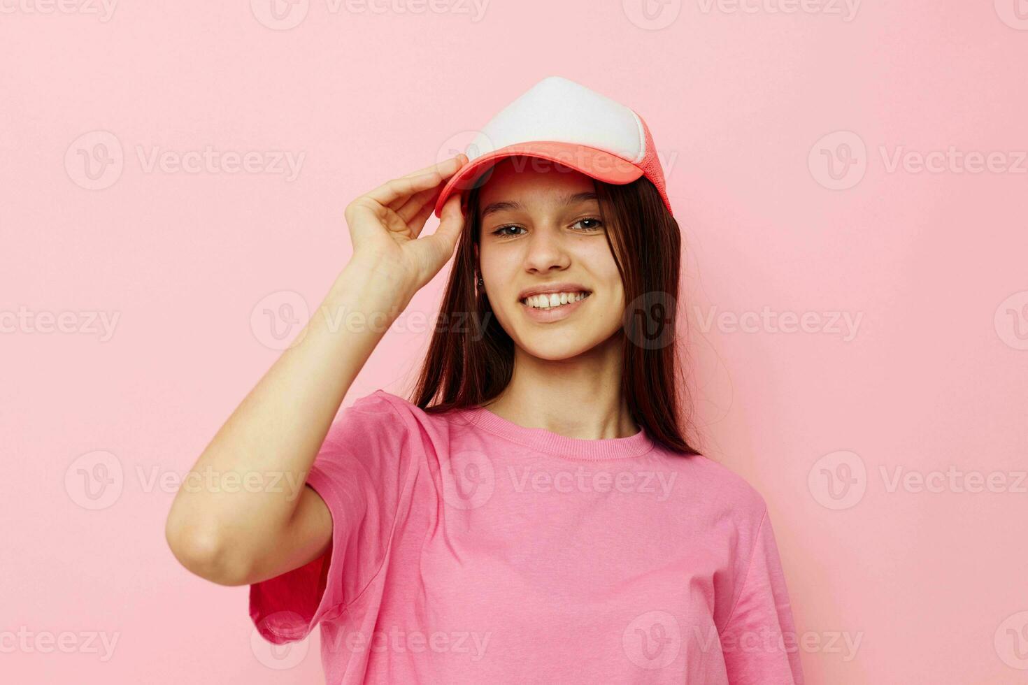 joven niña en un rosado camiseta con un gorra en su cabeza casual vestir foto