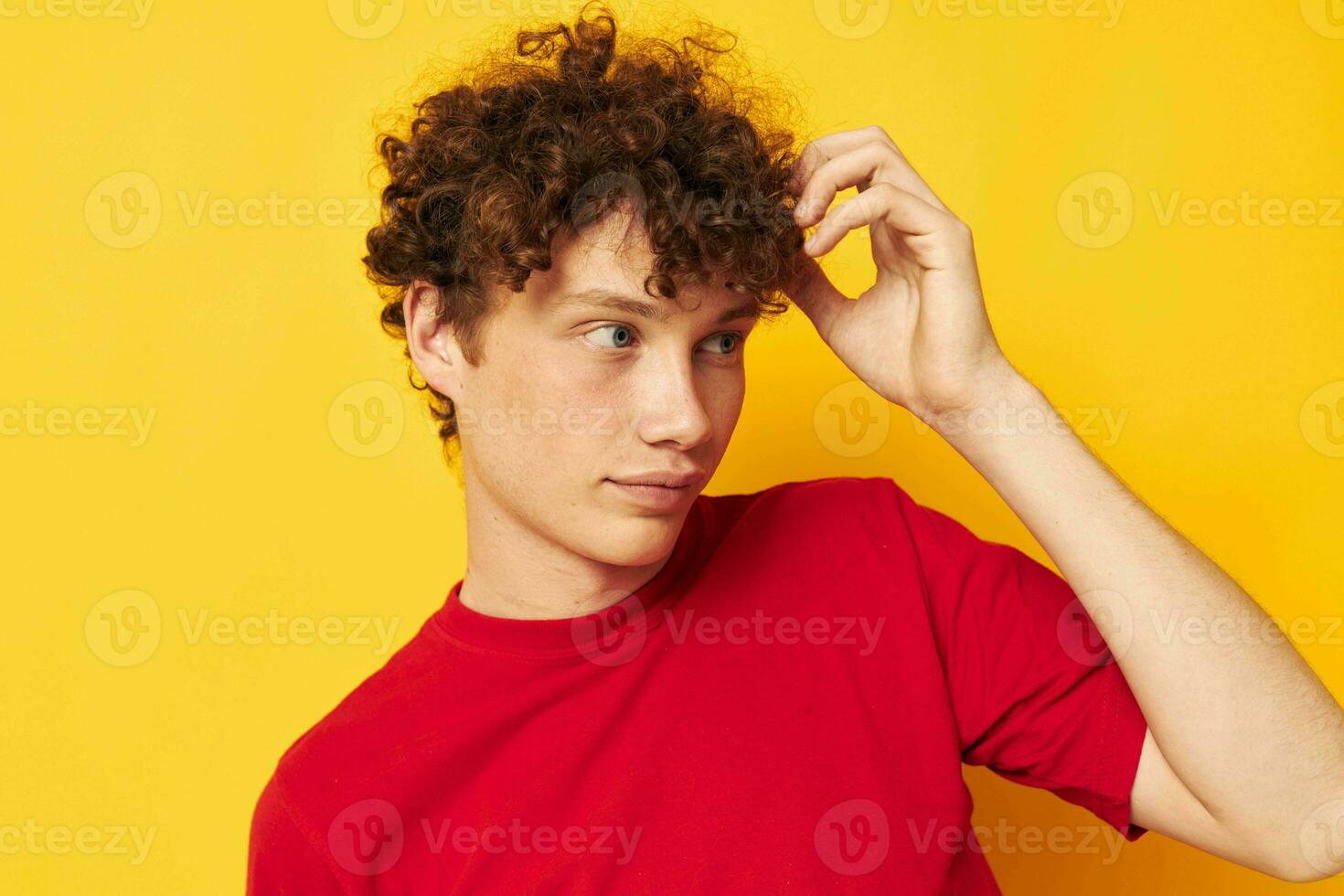 portrait of a young curly man red t shirt fun posing casual wear isolated background unaltered photo
