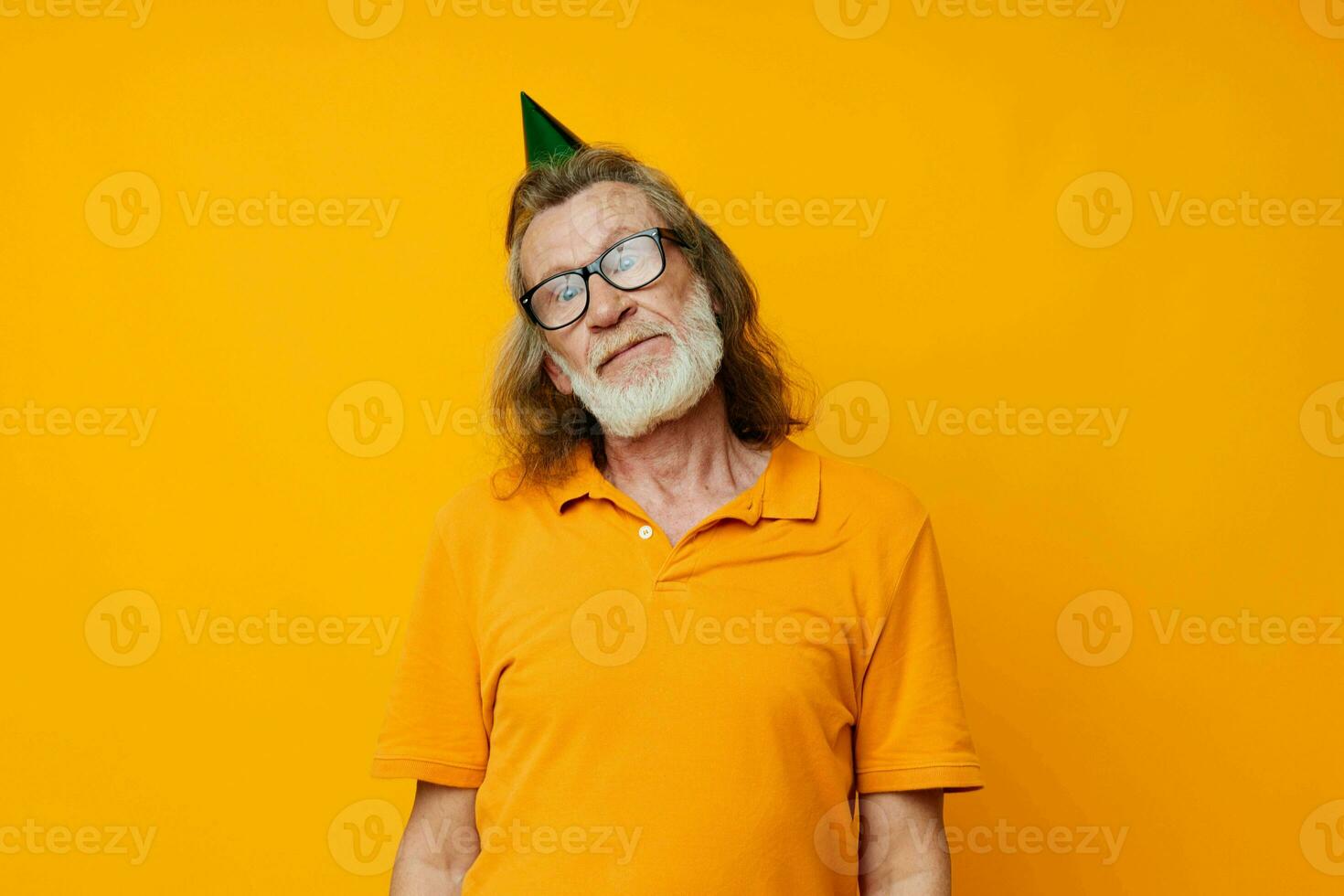 Portrait of happy senior man in a yellow t-shirt with a cap on his head fun yellow background photo