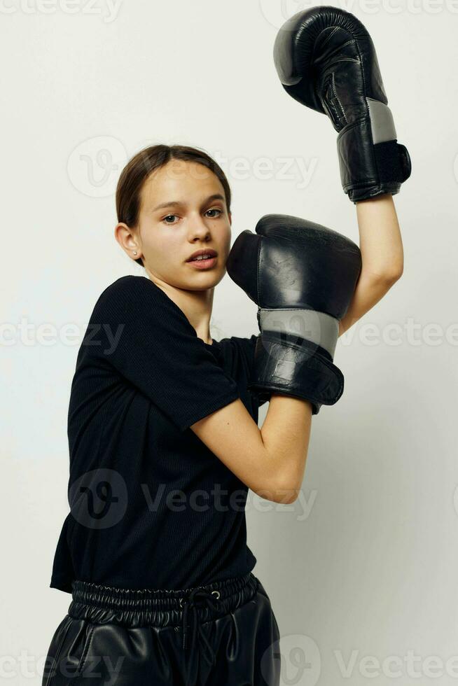 athletic woman in black sports uniform boxing gloves posing isolated background photo