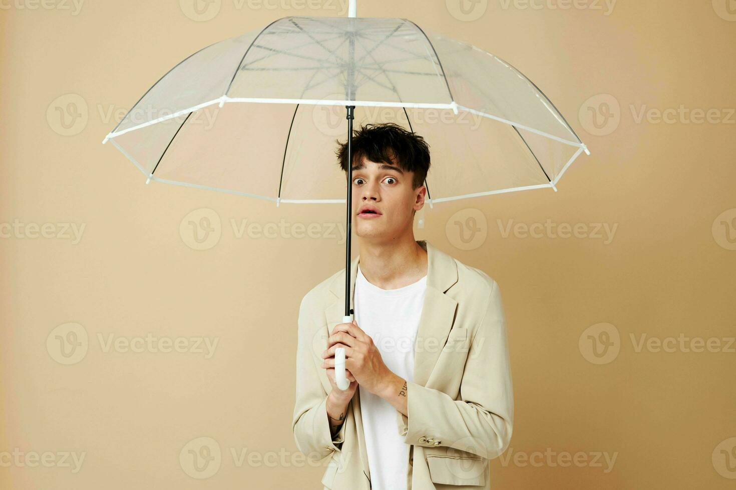 photo of a young guy in a white jacket with an open umbrella