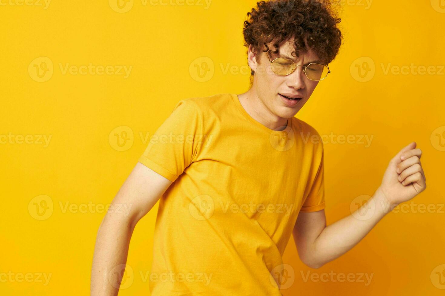 chico con rojo Rizado pelo amarillo camiseta lentes Moda mano gestos estilo de vida inalterado foto