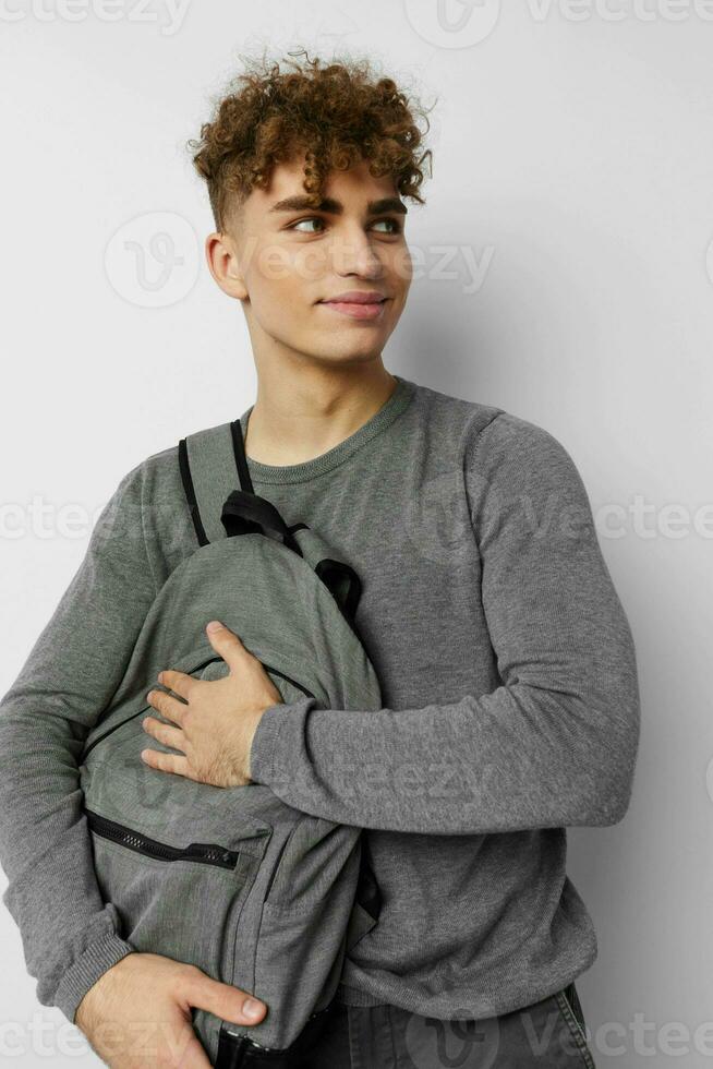handsome young man in a gray sweater backpack fashion isolated background photo