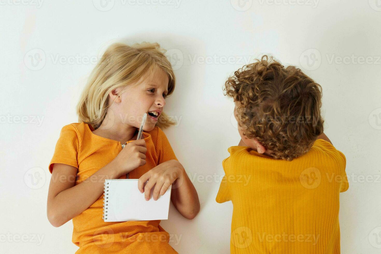 pequeño niños dibujo en cuadernos acostado en el piso ligero antecedentes inalterado foto