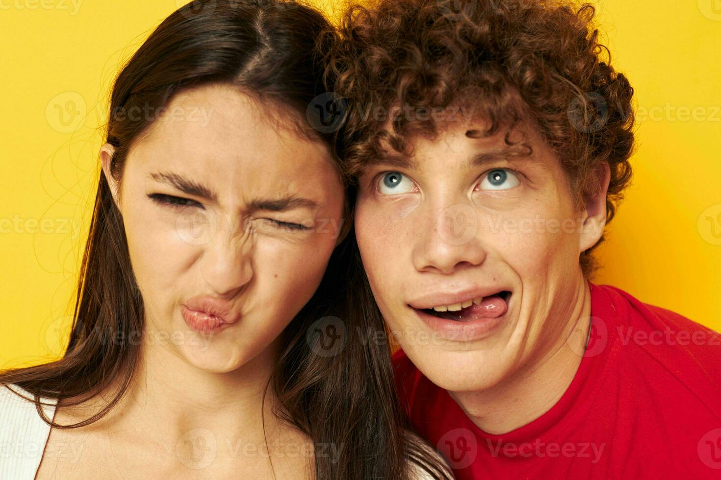 young boy and girl together posing emotions close-up yellow background unaltered photo