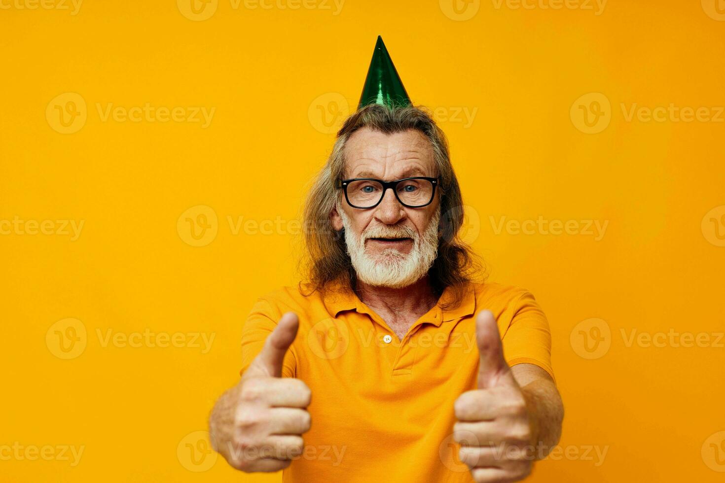 Portrait elderly man in a yellow t-shirt with a cap on his head fun yellow background photo