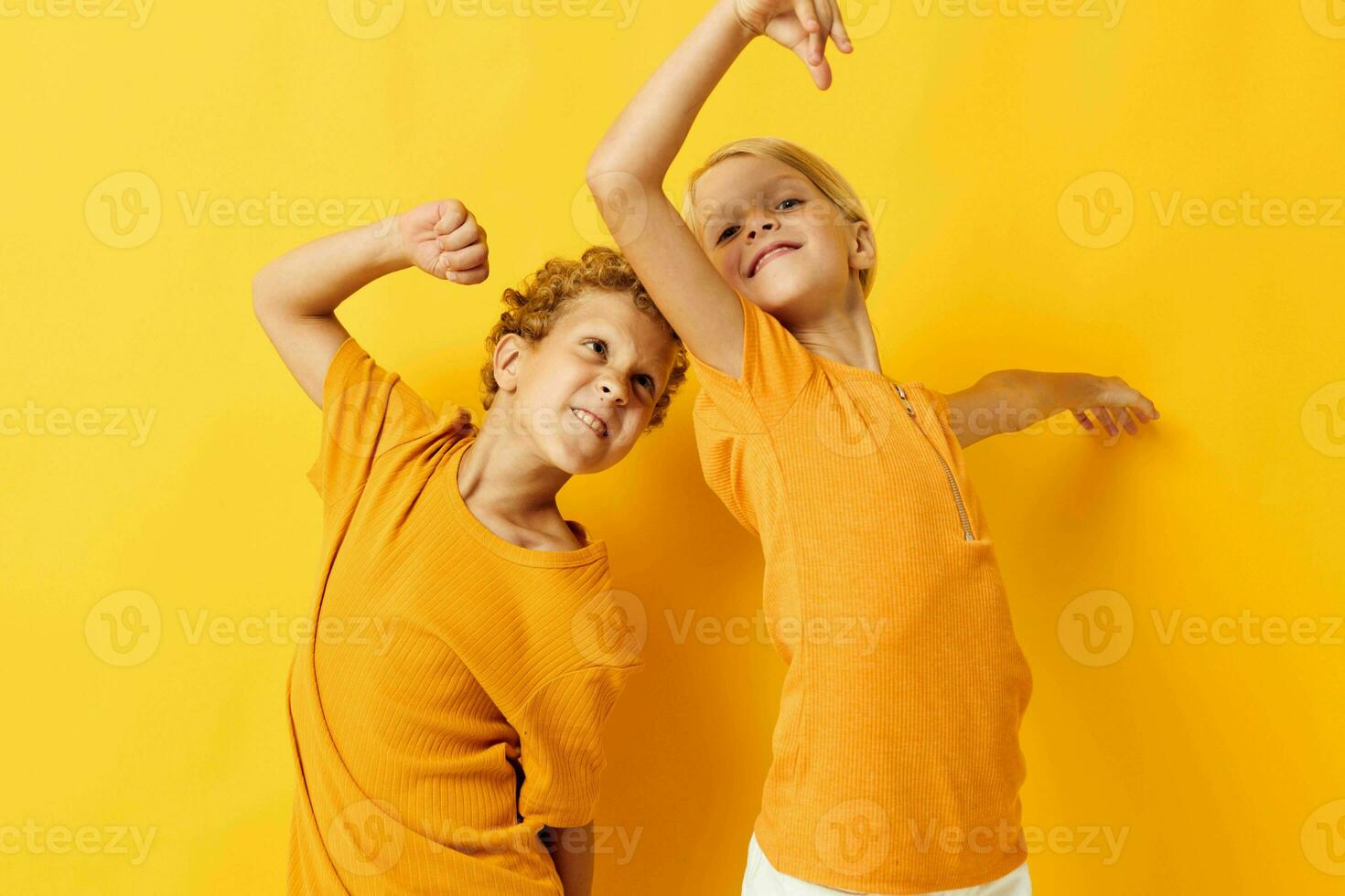 alegre niños en amarillo camisetas en pie lado por lado infancia emociones amarillo antecedentes inalterado foto