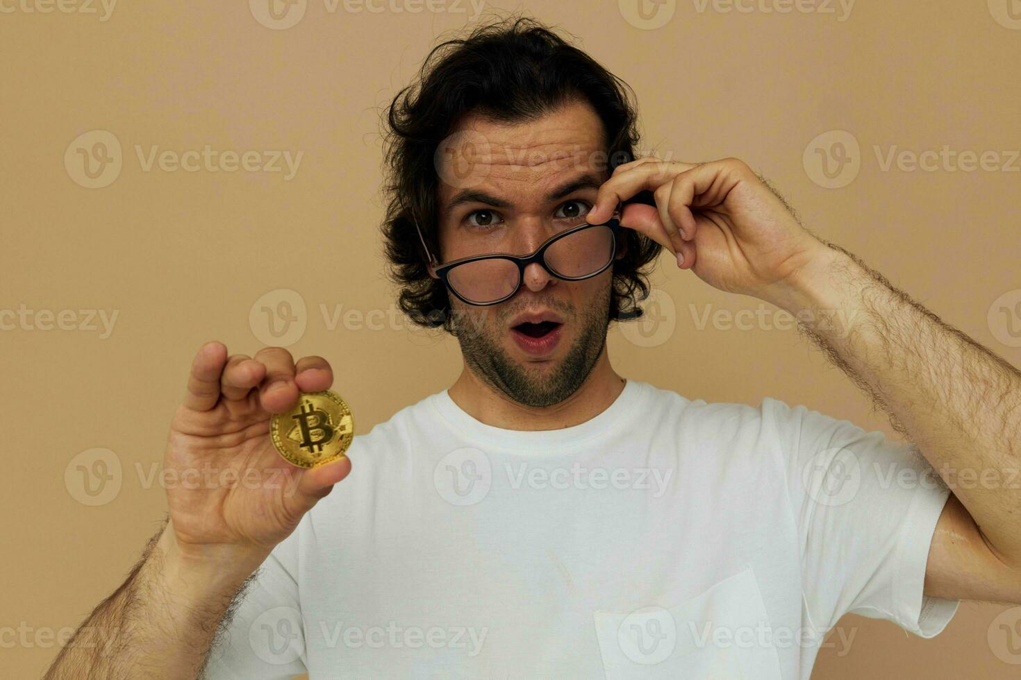 man in a white T-shirt with Bitcoin cryptocurrency beige background photo