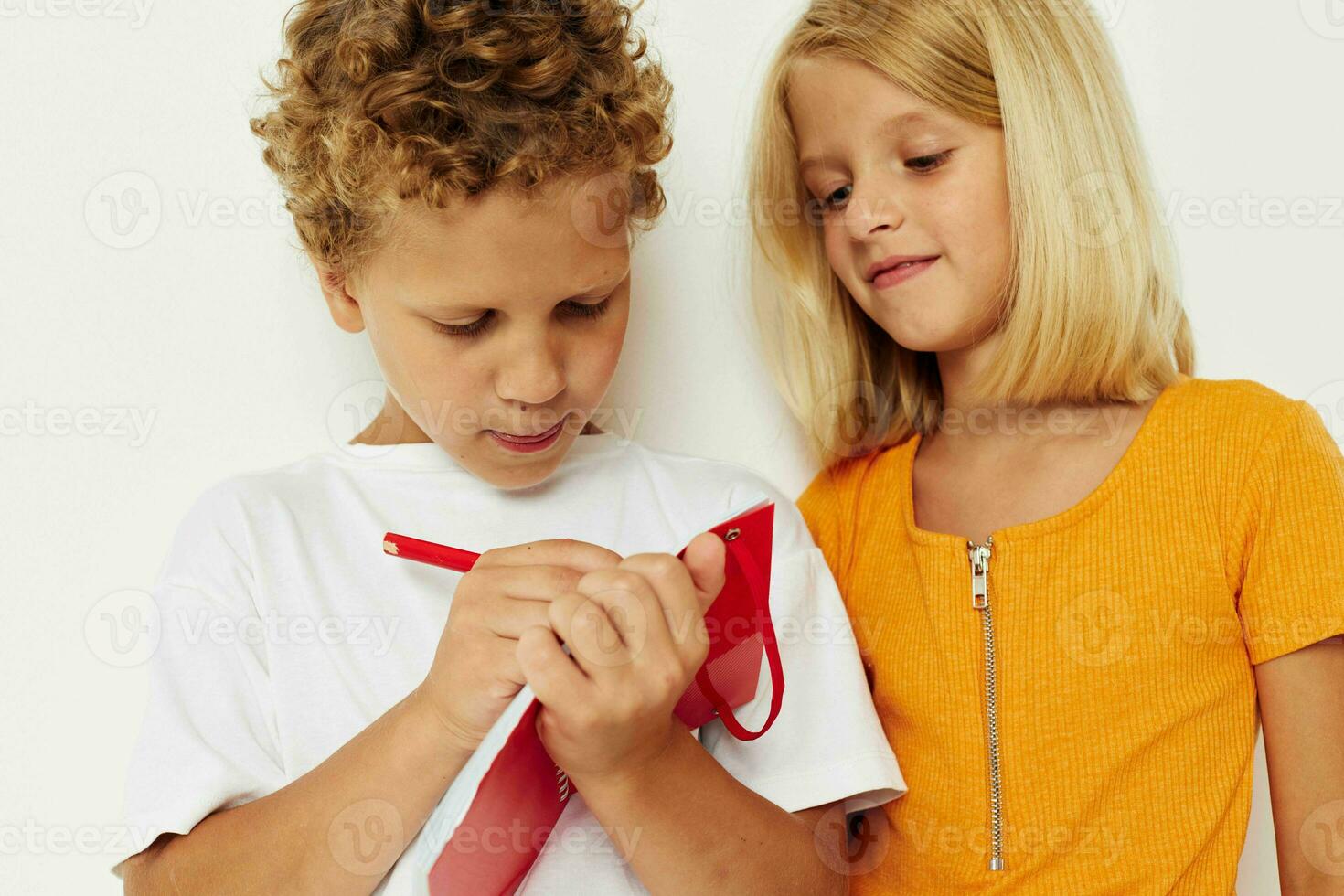 Boy and girl fun in colorful t-shirts with a notepad isolated background unaltered photo