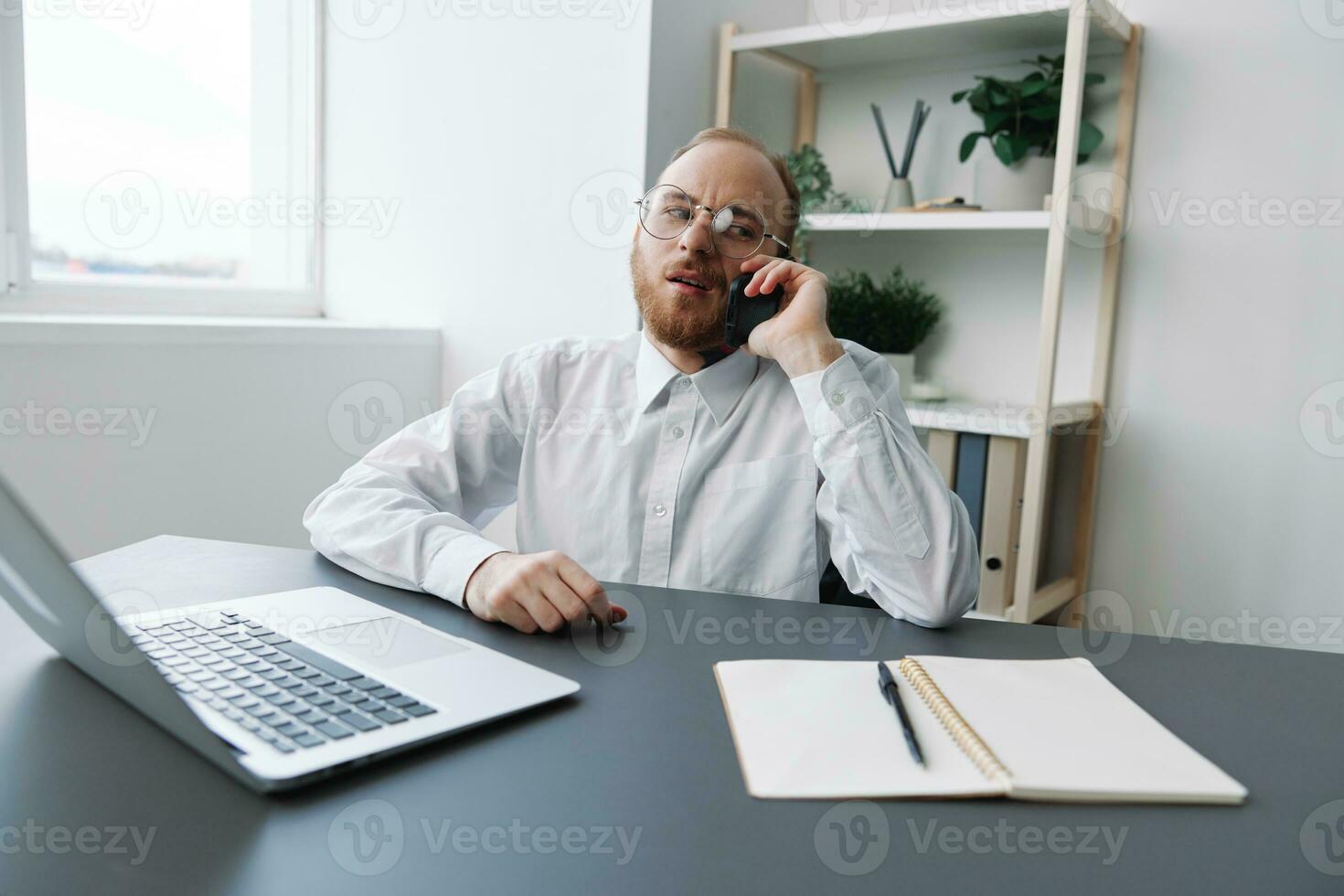 A man in a wheelchair a businessman with tattoos in the office works, talking on the phone screaming and angry, integration into society, the concept of working a person with disabilities photo