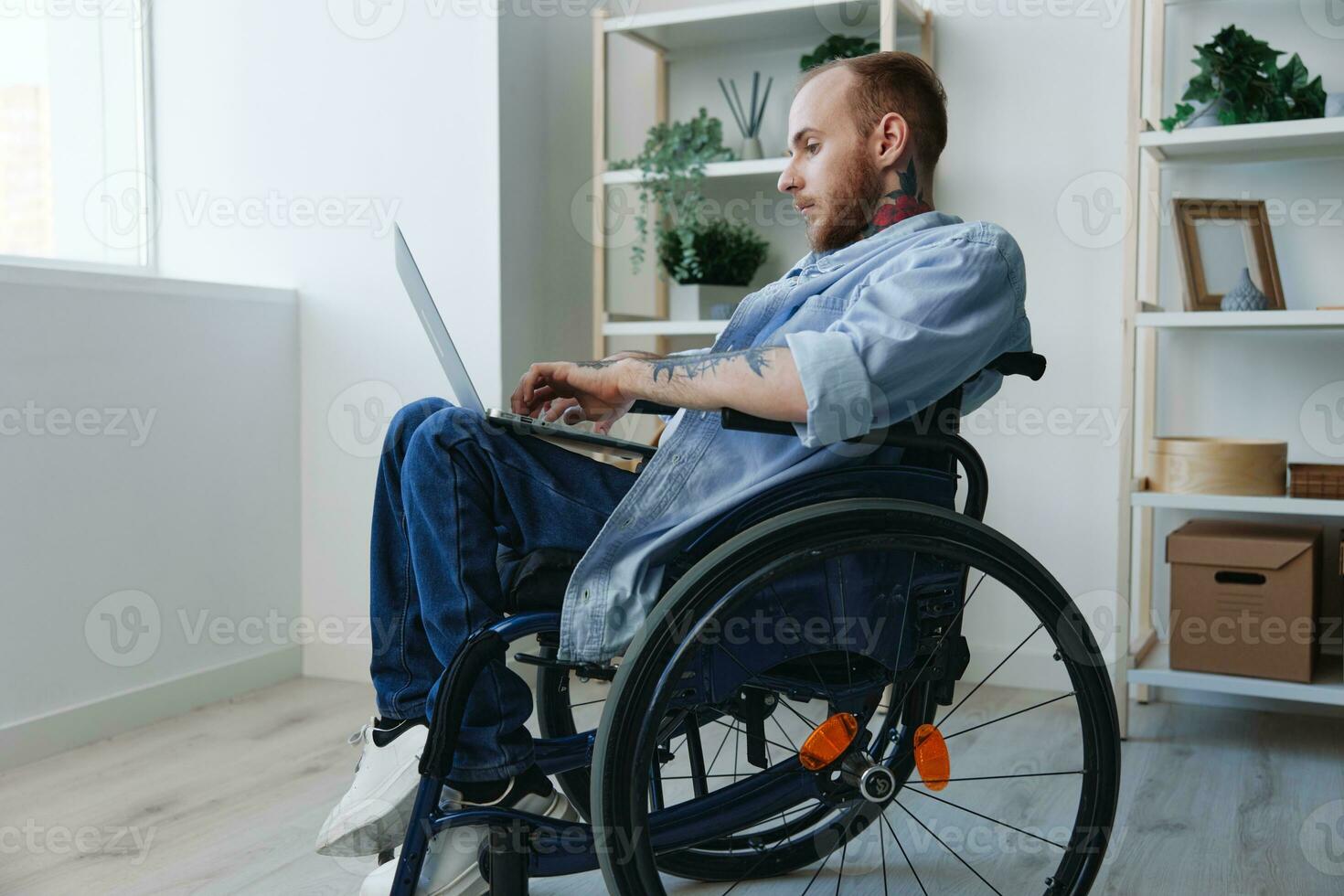 Man wheelchair freelancer working at laptop at home smile, working online, social networks and startup, copy space, integration into society, health concept man with disabilities, real person close-up photo