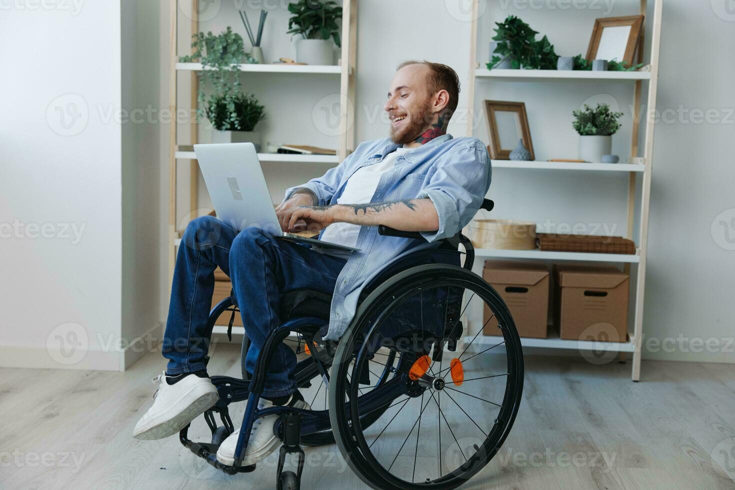 Man in wheelchair freelancer working at laptop at home smile, working online, social networks and startup, copy space, social integration, health concept man with disabilities, real person photo