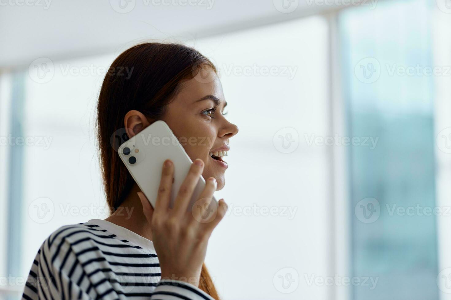 contento mujer sonrisa con dientes hablando en el teléfono retrato, hablando en un inteligente teléfono terminado el Internet en línea trabajo foto